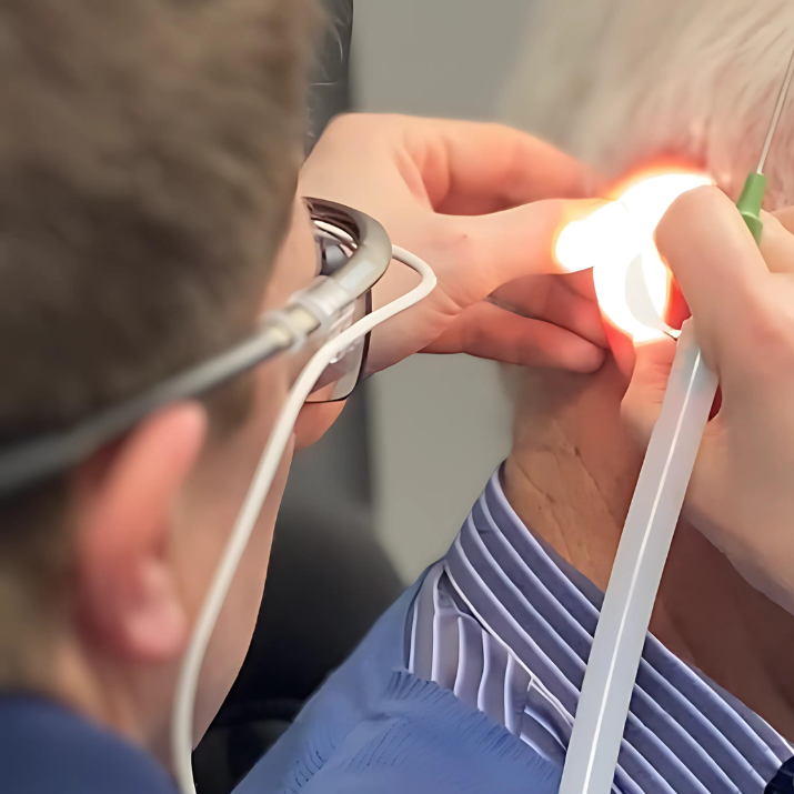 A light shines on a patient's ear as they undergo microsuction earwax removal.